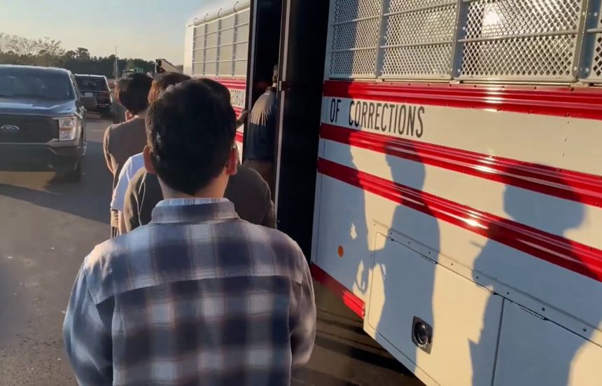 People will climb into a bus during the arrest of hundreds of ICE in a Hyundai plant in Ellabell, Georgia.