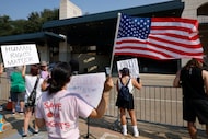 Demonstrators have signs before the eSport stadium, where a career exhibition for the US immigration ...